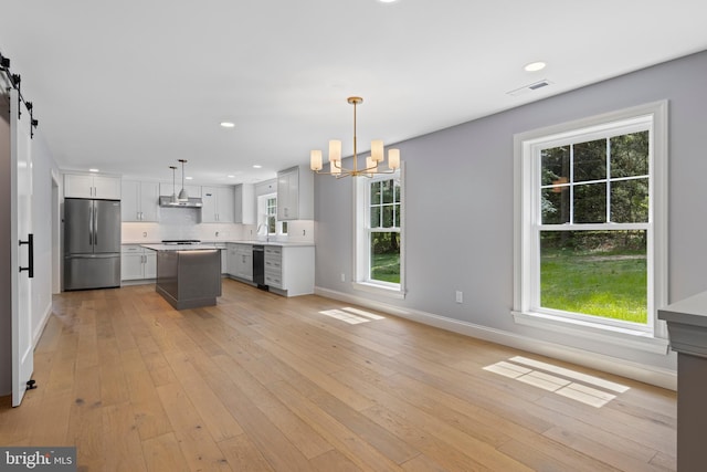 kitchen featuring freestanding refrigerator, baseboards, an inviting chandelier, and dishwasher