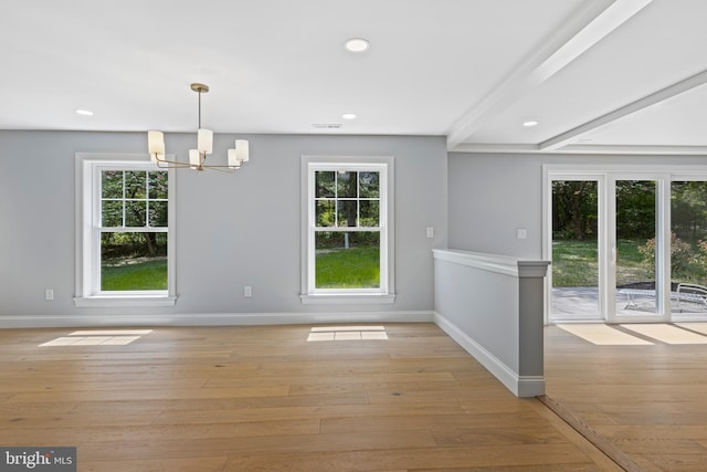 unfurnished dining area featuring a chandelier, baseboards, and light wood-style flooring
