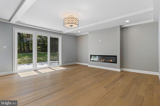 unfurnished living room with recessed lighting, baseboards, hardwood / wood-style flooring, a fireplace, and beam ceiling
