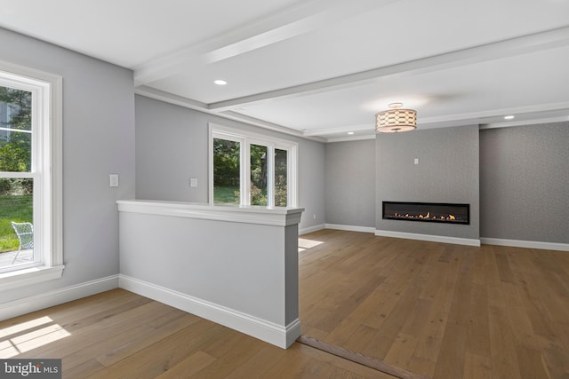 unfurnished living room with a fireplace, baseboards, and a healthy amount of sunlight