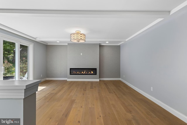 unfurnished living room with light wood-type flooring, a fireplace, baseboards, and recessed lighting