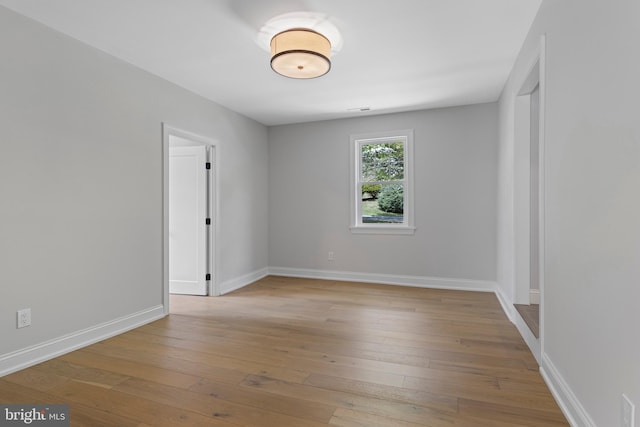 unfurnished room featuring wood-type flooring and baseboards