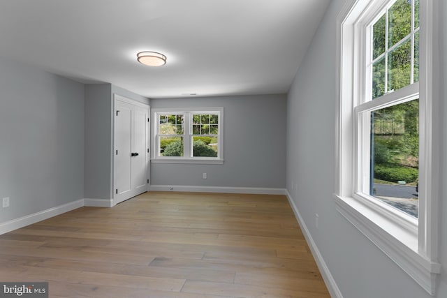 unfurnished room with light wood-style floors and baseboards