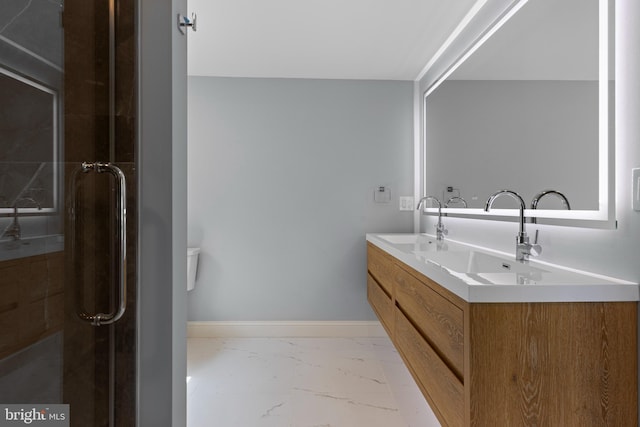 full bath with a stall shower, marble finish floor, and a sink