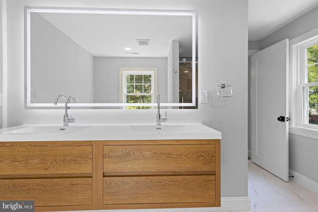 bathroom with plenty of natural light, visible vents, marble finish floor, and a sink