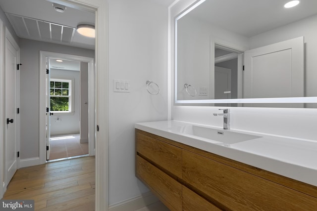 bathroom featuring wood finished floors, visible vents, baseboards, vanity, and recessed lighting