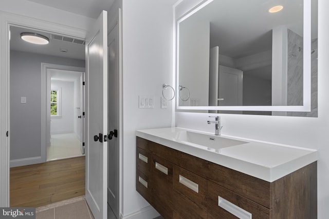 bathroom featuring vanity, baseboards, and wood finished floors