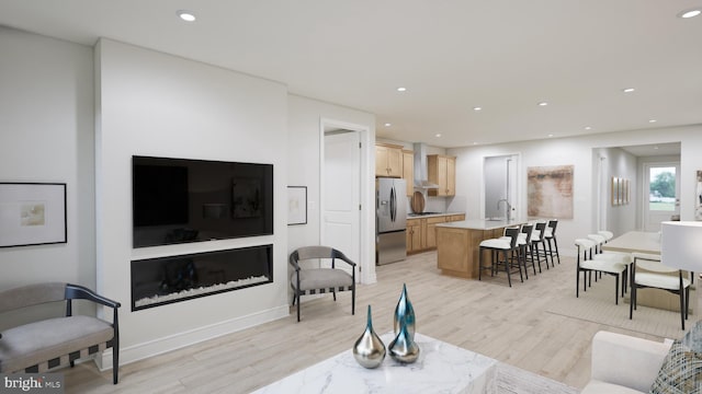 living area with recessed lighting, light wood-style flooring, and baseboards