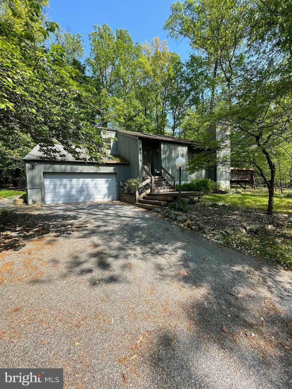 mid-century modern home featuring aphalt driveway