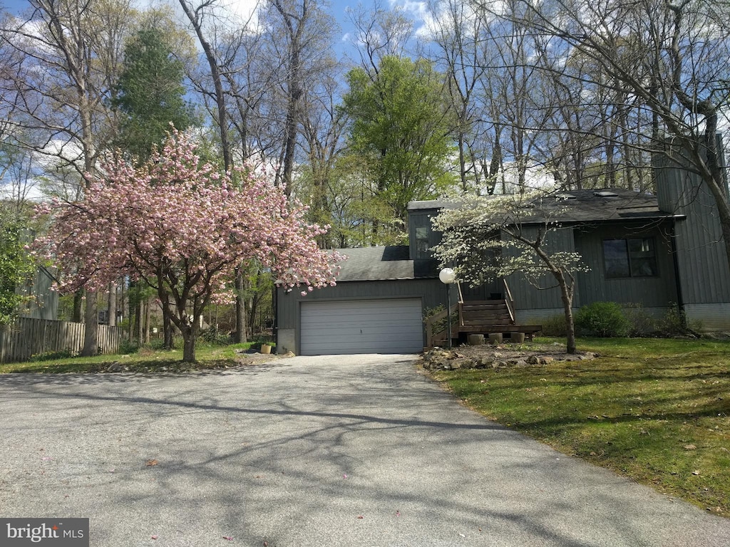 view of front of house with driveway, fence, and a garage