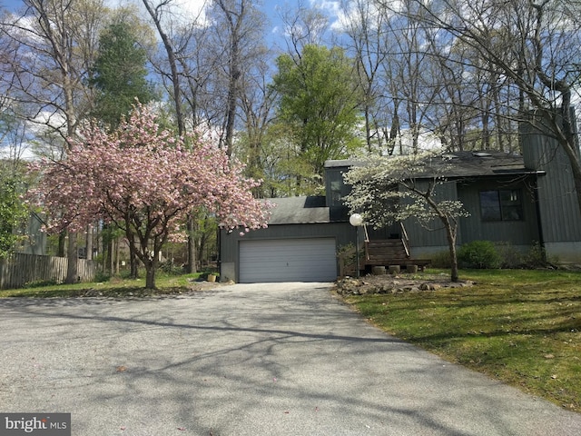 view of front of house with driveway, fence, and a garage