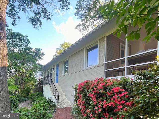 view of home's exterior featuring brick siding and stairs