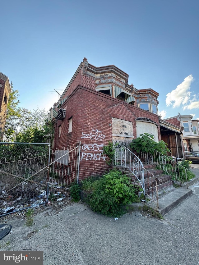 view of front facade featuring brick siding and fence