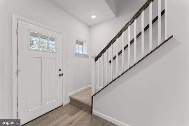 foyer entrance with stairs, recessed lighting, baseboards, and wood finished floors