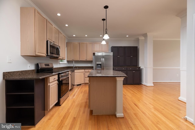 kitchen featuring appliances with stainless steel finishes, light brown cabinets, a center island, light wood-style floors, and ornamental molding