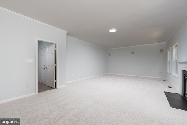 unfurnished living room with carpet floors, crown molding, baseboards, and a fireplace with flush hearth