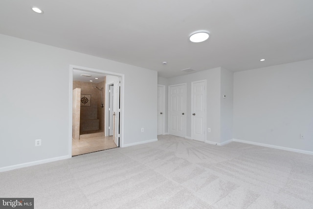 unfurnished bedroom with light carpet, baseboards, recessed lighting, and ensuite bath