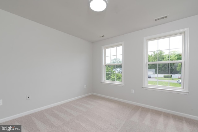 empty room featuring baseboards and light colored carpet