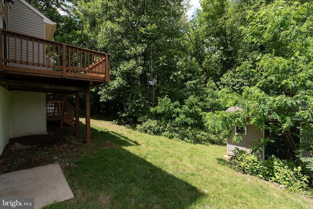 view of green lawn with a wooden deck and stairway