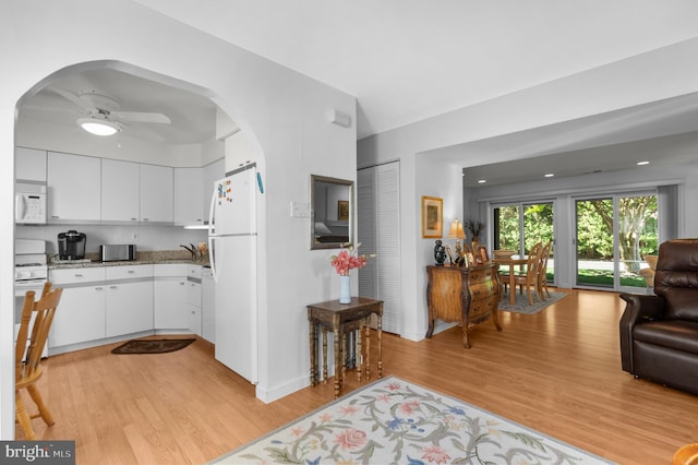 5025A S Convent Ln Unit 142, Philadelphia, PA 19114 - kitchen featuring white appliances, arched walkways, light wood-style floors, and white cabinetry