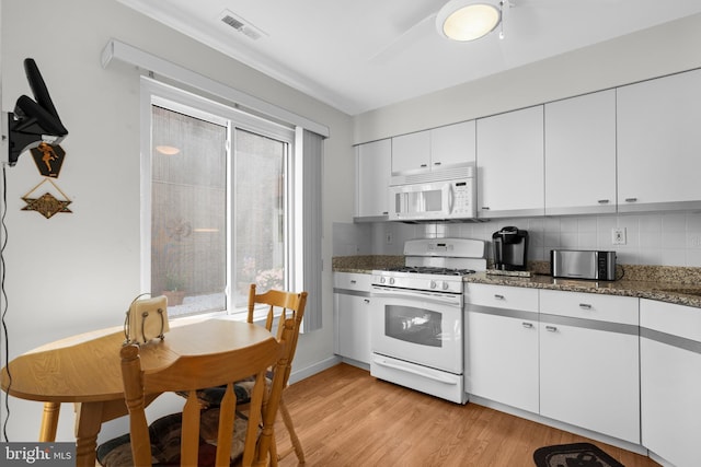 5025A S Convent Ln Unit 142, Philadelphia, PA 19114 - kitchen featuring white appliances, light wood-type flooring, white cabinets, dark stone counters, and tasteful backsplash