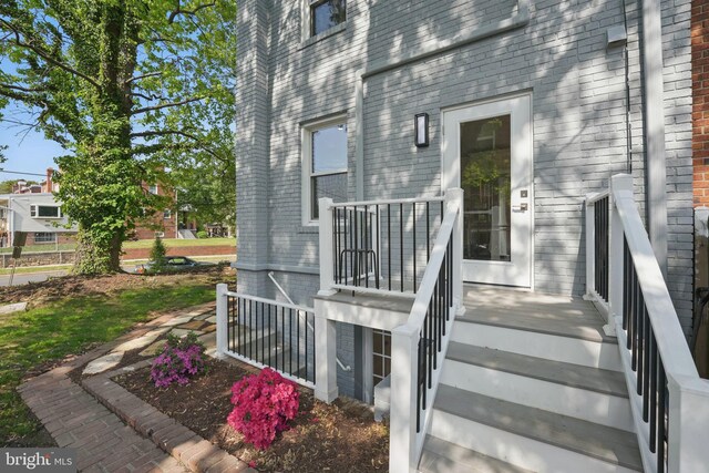 view of exterior entry featuring brick siding