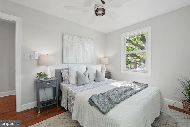 bedroom featuring a ceiling fan, baseboards, and wood finished floors