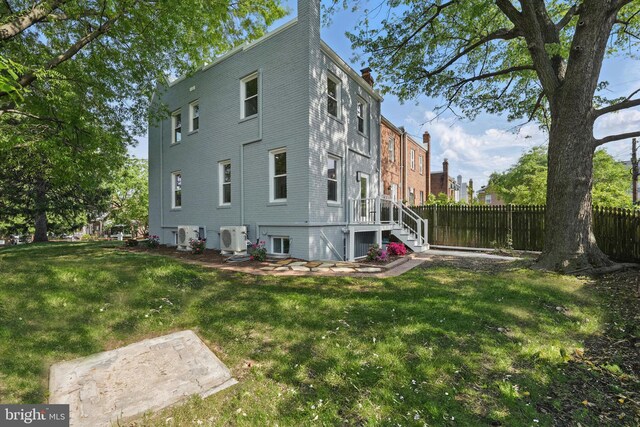 view of property exterior featuring a lawn, ac unit, fence, and a chimney