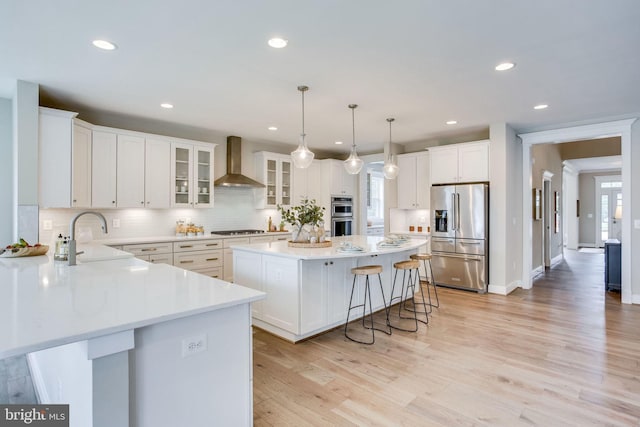 3919 Pineland St, Fairfax, VA 22031 - kitchen featuring appliances with stainless steel finishes, a breakfast bar, wall chimney exhaust hood, a center island, and tasteful backsplash