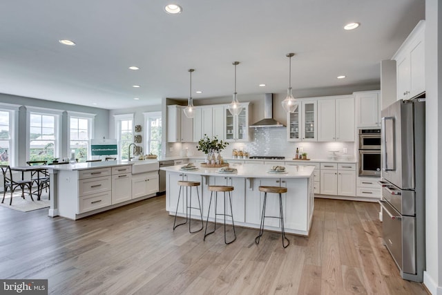 3919 Pineland St, Fairfax, VA 22031 - kitchen featuring a kitchen bar, tasteful backsplash, white cabinetry, stainless steel appliances, and wall chimney exhaust hood