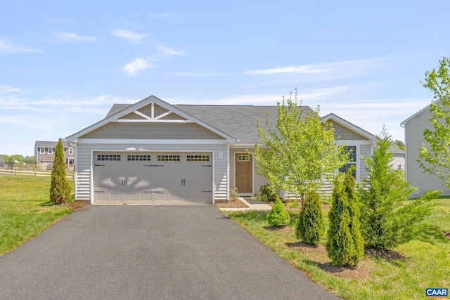 view of front of home featuring driveway, a front yard, and a garage