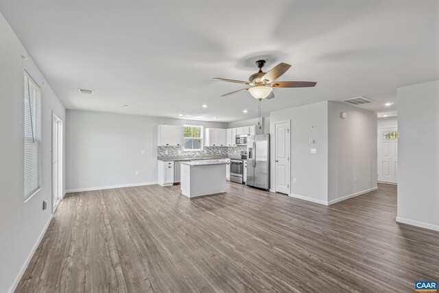 unfurnished living room with baseboards, ceiling fan, recessed lighting, and wood finished floors