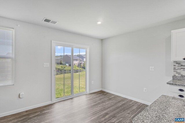 unfurnished dining area with baseboards, recessed lighting, wood finished floors, and visible vents