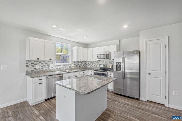 kitchen featuring appliances with stainless steel finishes, tasteful backsplash, and dark wood finished floors