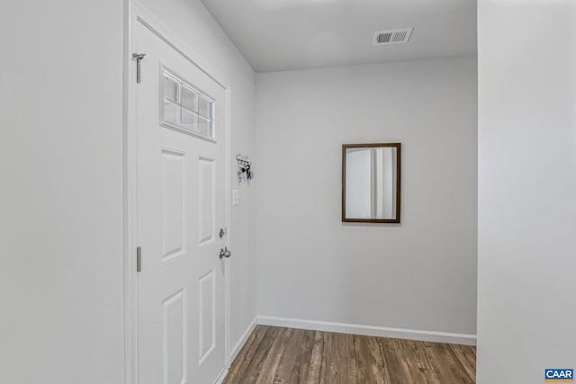 doorway to outside featuring visible vents, baseboards, and dark wood-style floors