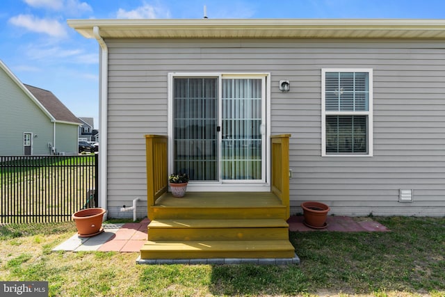 rear view of property featuring fence and a lawn