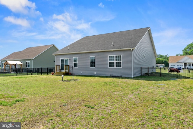 rear view of house featuring a fenced backyard and a yard