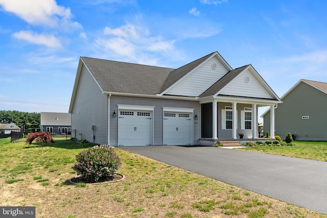 view of front of property with fence, an attached garage, a front lawn, a porch, and driveway