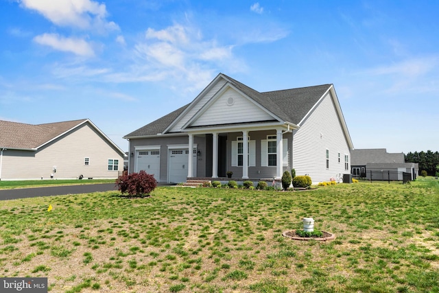greek revival house featuring covered porch, an attached garage, and a front yard