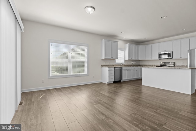 kitchen featuring dark wood-type flooring, recessed lighting, baseboards, and appliances with stainless steel finishes