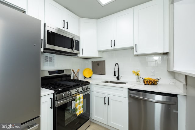 160 Talbott St Unit T5, Rockville, MD 20852 - kitchen featuring appliances with stainless steel finishes, a sink, light stone counters, white cabinetry, and decorative backsplash