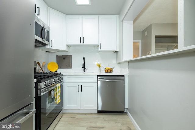 160 Talbott St Unit T5, Rockville, MD 20852 - kitchen featuring appliances with stainless steel finishes, a sink, tasteful backsplash, light wood finished floors, and white cabinetry