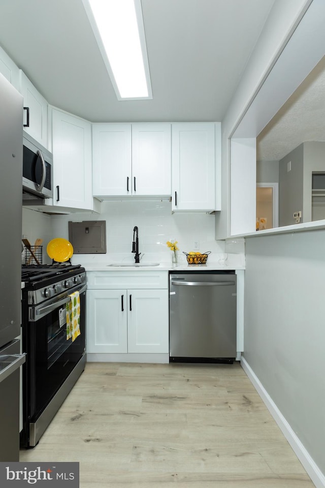160 Talbott St Unit T5, Rockville, MD 20852 - kitchen featuring stainless steel appliances, a sink, light wood-type flooring, white cabinets, and light countertops