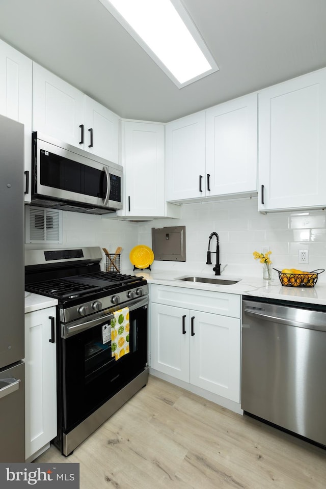 160 Talbott St Unit T5, Rockville, MD 20852 - kitchen with stainless steel appliances, a sink, light countertops, light wood finished floors, and tasteful backsplash