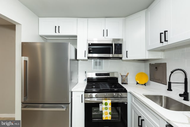 160 Talbott St Unit T5, Rockville, MD 20852 - kitchen featuring stainless steel appliances, a sink, light stone countertops, and white cabinetry