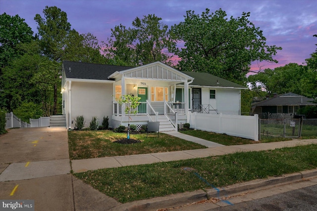 view of front of house with fence, a gate, covered porch, and board and batten siding