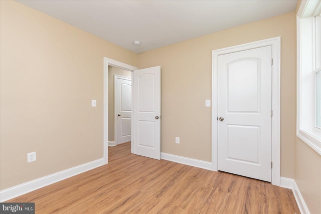 unfurnished bedroom featuring baseboards and light wood-type flooring
