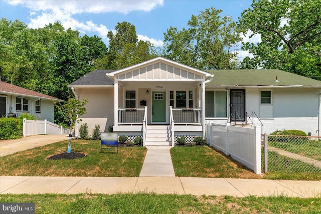 view of front of home featuring fence, board and batten siding, a porch, and a front yard