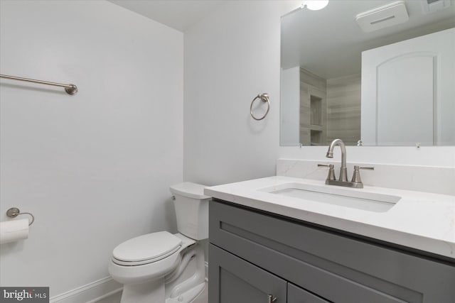 bathroom featuring vanity, baseboards, toilet, and visible vents