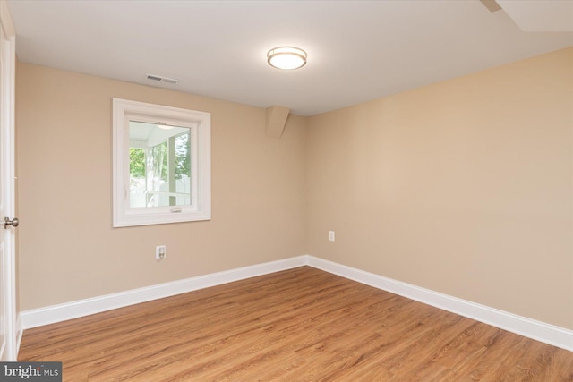 spare room featuring baseboards, visible vents, and light wood-type flooring